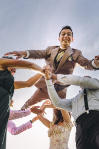 photographie d'un marié lancé en l'air par ses témoins prise par un photographe de mariage