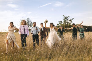 mariés et leurs témoins courant dans un champ